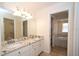 Bathroom with double vanity, granite countertop, and a view into the tub and shower area at 9377 Preston Rd, Brooksville, FL 34601