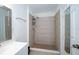 Updated bathroom featuring a neutral tiled shower with a rain shower head and ample storage space at 9377 Preston Rd, Brooksville, FL 34601