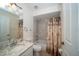 Cozy bathroom with a tub-shower combo, a granite countertop sink vanity, and stylish palm tree printed shower curtain at 9377 Preston Rd, Brooksville, FL 34601