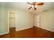Bright bedroom features hardwood floors, a ceiling fan, and a convenient walk-in closet at 9377 Preston Rd, Brooksville, FL 34601