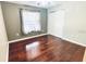 Well-lit bedroom with neutral walls, hardwood floors, closet, and a large window at 9377 Preston Rd, Brooksville, FL 34601