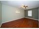 Bedroom with hardwood floors, a ceiling fan, and natural light from two windows at 9377 Preston Rd, Brooksville, FL 34601