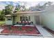 Charming front porch with cozy seating and a well-manicured garden bed, creating a welcoming entryway at 9377 Preston Rd, Brooksville, FL 34601