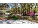 Landscaped front yard features vibrant flowers and mature trees, adding to the home's curb appeal at 9377 Preston Rd, Brooksville, FL 34601