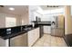 Modern kitchen featuring stainless steel appliances, granite countertops, and tiled floors at 9377 Preston Rd, Brooksville, FL 34601