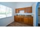 Kitchen with wood cabinets, double stainless sink, hard surface floors, and large window at 9377 Preston Rd, Brooksville, FL 34601