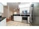 Bright kitchen with stainless steel appliances, black countertops, and tiled flooring at 9377 Preston Rd, Brooksville, FL 34601