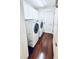 Efficient laundry room showcasing hardwood floors, washer and dryer, and ample cabinet space at 9377 Preston Rd, Brooksville, FL 34601