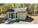 Back of house featuring a screened-in patio, clean siding, and lush backyard, designed for outdoor enjoyment at 9377 Preston Rd, Brooksville, FL 34601