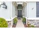 Inviting front entrance with stone accents, decorative plants, and a stylish dark-colored front door at 12503 Candleberry Cir, Tampa, FL 33635