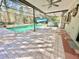 A screened-in pool with an adjacent tiled patio area, ceiling fan, and a spa at 13076 Kanawha Dr, Weeki Wachee, FL 34614