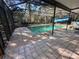 Screened-in pool area featuring a clear pool and surrounding tiled deck for relaxation at 13076 Kanawha Dr, Weeki Wachee, FL 34614
