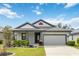 Charming single-story home with manicured lawn, gray trim, and attached two-car garage at 13364 Sea Bridge Dr, Hudson, FL 34669