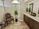Bathroom featuring double sinks, tile flooring, and a chair at 16209 Belle Meade Blvd, Odessa, FL 33556