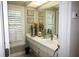 Bright bathroom with shutters, a large mirror, white countertops, and decorative elements at 16209 Belle Meade Blvd, Odessa, FL 33556
