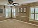 Bedroom with neutral carpeting, multiple windows with white shutters, ceiling fan, and wall art at 16209 Belle Meade Blvd, Odessa, FL 33556