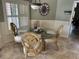 Charming dining area featuring a glass-top table, ornate chairs, and natural light from shuttered windows at 16209 Belle Meade Blvd, Odessa, FL 33556