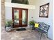Inviting front entrance with double doors, decorative planters, and bench with a 'HOME' pillow at 16209 Belle Meade Blvd, Odessa, FL 33556