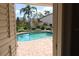 View of private pool from doorway, with a brick patio and lush landscaping in the background at 16209 Belle Meade Blvd, Odessa, FL 33556