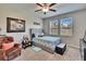 Cozy bedroom featuring a ceiling fan, two windows and a comfortable grey upholstered bed at 16868 Scuba Crest St, Wimauma, FL 33598