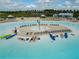 Aerial view of lagoon with beach cabanas, kayaks, clear water, and a tropical ambiance at 16868 Scuba Crest St, Wimauma, FL 33598
