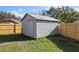 Backyard shed with a wooden fence and a large tree in the background at 1801 Rudder Dr, Valrico, FL 33594