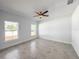 Bright bedroom features tile floors, a ceiling fan, and two windows at 22442 Peachland Blvd, Port Charlotte, FL 33954