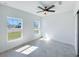 Bright bedroom features tile floors, a ceiling fan, and two windows at 22442 Peachland Blvd, Port Charlotte, FL 33954