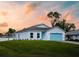 Charming single-story home featuring a blue garage door, a well-manicured lawn, and a serene neighborhood setting at 22442 Peachland Blvd, Port Charlotte, FL 33954