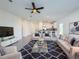 Bright open-concept living room featuring a ceiling fan, modern furniture, and view into the kitchen at 22442 Peachland Blvd, Port Charlotte, FL 33954