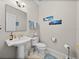 Bright bathroom featuring a pedestal sink, decorative towels, and beach-themed wall art at 240 108Th Ave # 102, Treasure Island, FL 33706