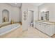 An elegant bathroom includes a soaking tub, white vanity and beautiful fixtures at 240 108Th Ave # 102, Treasure Island, FL 33706