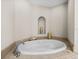 A close up on a soaking tub with marble accents and walls at 240 108Th Ave # 102, Treasure Island, FL 33706