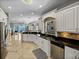 Open-concept kitchen with granite counters and stainless steel appliances, flowing into dining area at 240 108Th Ave # 102, Treasure Island, FL 33706