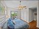 Bright and airy bedroom with a ceiling fan, balcony, and hardwood floors at 240 108Th Ave # 102, Treasure Island, FL 33706