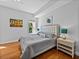 Comfortable bedroom with a tufted headboard, wood floors and stylish furnishings at 240 108Th Ave # 102, Treasure Island, FL 33706
