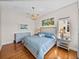 Comfortable main bedroom featuring a tufted headboard, wood floors and stylish furnishings at 240 108Th Ave # 102, Treasure Island, FL 33706