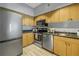 Modern kitchen featuring stainless steel appliances, light wood cabinets, and plenty of storage space at 2402 W Azeele St # 423, Tampa, FL 33609