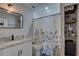 Well-lit bathroom featuring granite countertops, updated fixtures, and a floral shower curtain at 315 40Th S St, St Petersburg, FL 33711
