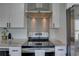 Chef kitchen with stainless steel hood, tiled backsplash, and modern fixtures at 315 40Th S St, St Petersburg, FL 33711