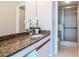 Bathroom showcasing granite countertops and a glass-enclosed shower at 3211 W Swann Ave # 502, Tampa, FL 33609
