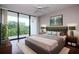 Bright bedroom with a king bed, balcony access and ceiling fan providing an airy, comfortable atmosphere at 3211 W Swann Ave # 502, Tampa, FL 33609