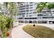 Exterior view of a condo building featuring lush landscaping and a convenient covered parking area at 3211 W Swann Ave # 502, Tampa, FL 33609
