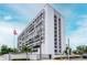 Modern condominium building with a white facade, multiple balconies and an American flag in the front yard at 3211 W Swann Ave # 502, Tampa, FL 33609