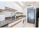 Bright kitchen featuring stainless steel sink, granite countertops, and convenient in-unit washer/dryer at 3211 W Swann Ave # 502, Tampa, FL 33609