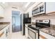 Kitchen with stainless steel appliances, granite countertops and tile floors with view to Living area at 3211 W Swann Ave # 502, Tampa, FL 33609
