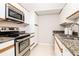 Cozy kitchen features stainless steel appliances and granite countertops with tile flooring at 3211 W Swann Ave # 502, Tampa, FL 33609