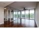 Large living room featuring mirrored wall, ceiling fan, hardwood floors and access to balcony at 3211 W Swann Ave # 502, Tampa, FL 33609