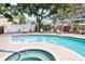 Community pool with hot tub and lounge chairs surrounded by beautiful landscaping and mature trees at 3211 W Swann Ave # 502, Tampa, FL 33609