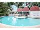 Relaxing community pool and hot tub surrounded by brick pavers and mature shade trees at 3211 W Swann Ave # 502, Tampa, FL 33609